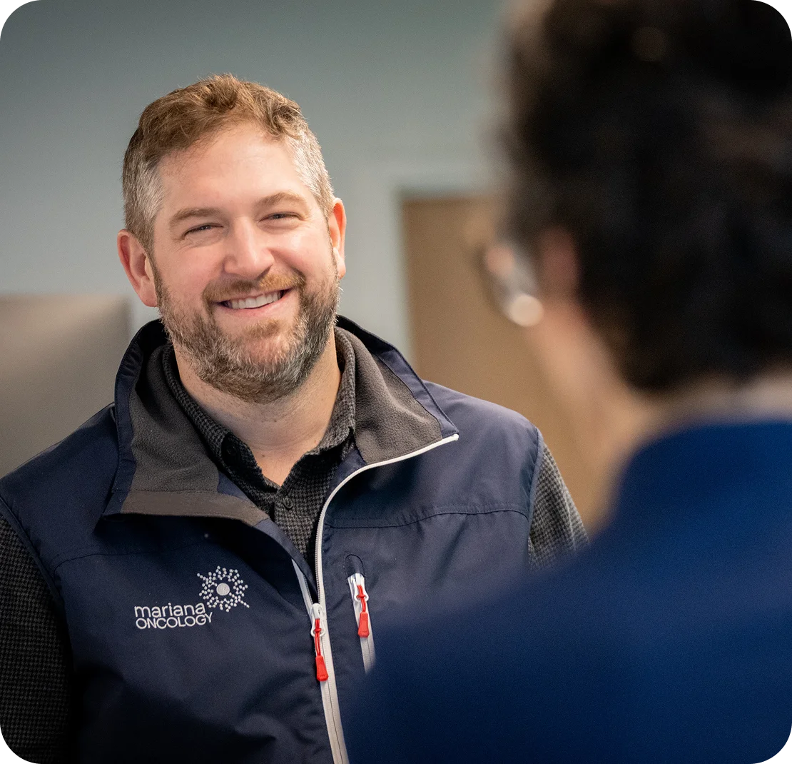 Close up shot of two Mariana Oncology employees smiling and conversing